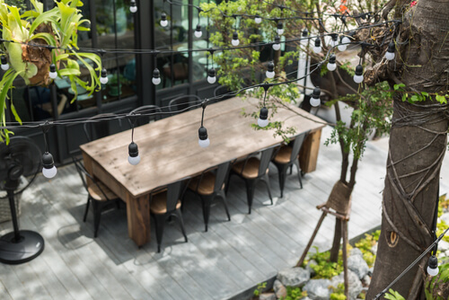 Timber Decking with Dining table in backyard garden Focus on bulb

